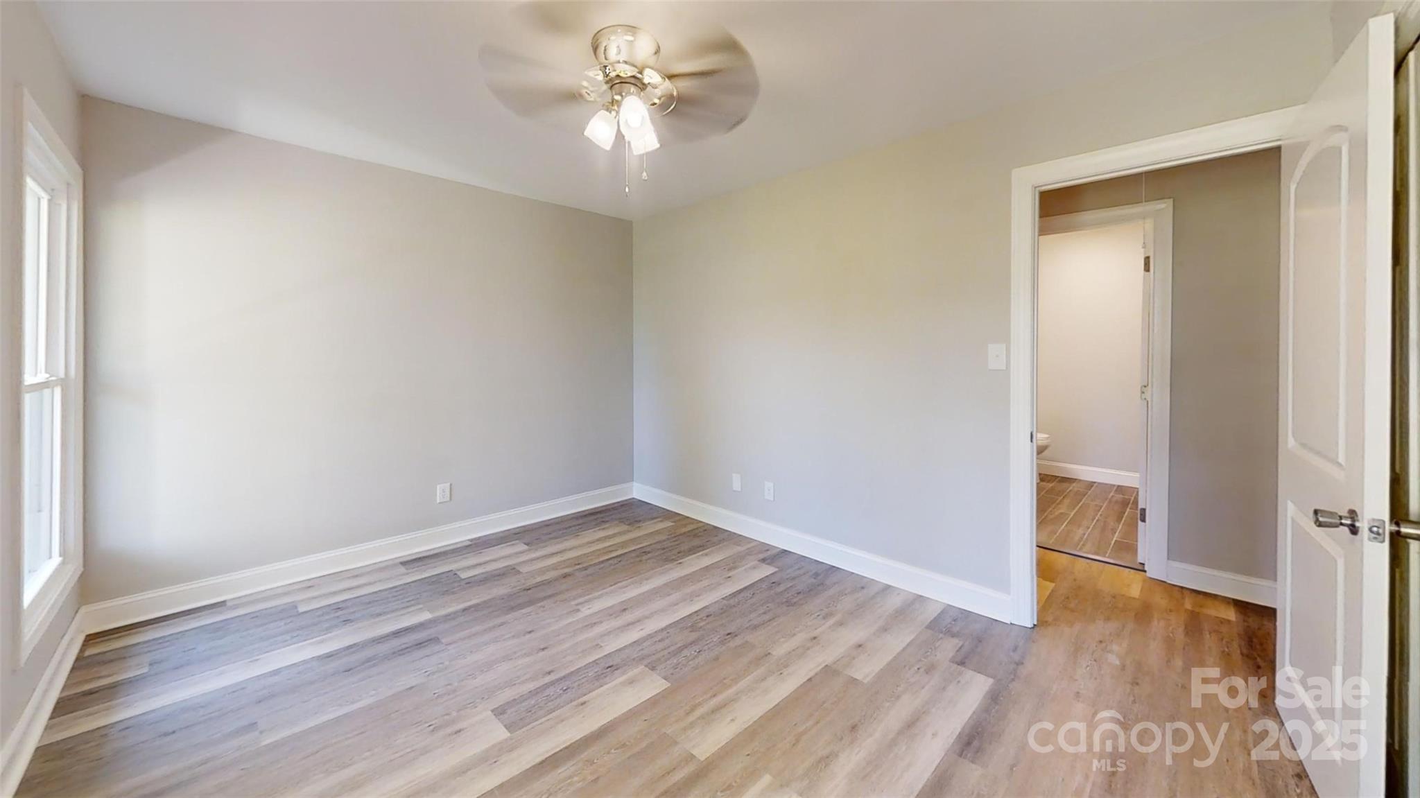 5406 Christopher Road Iron Station, NC 28080 - Photo 13 of 23 an empty room with wooden floor and ceiling fan