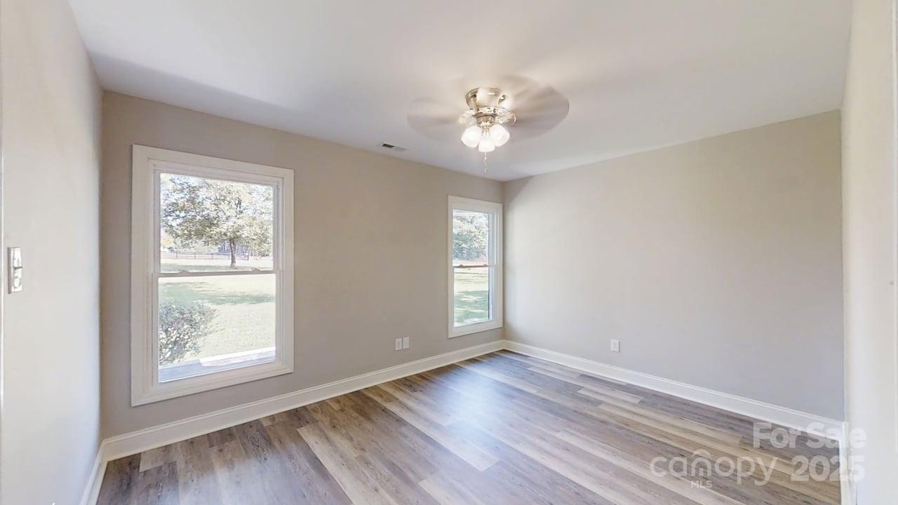 5406 Christopher Road Iron Station, NC 28080 - Photo 14 of 23 a view of an empty room with wooden floor and a window