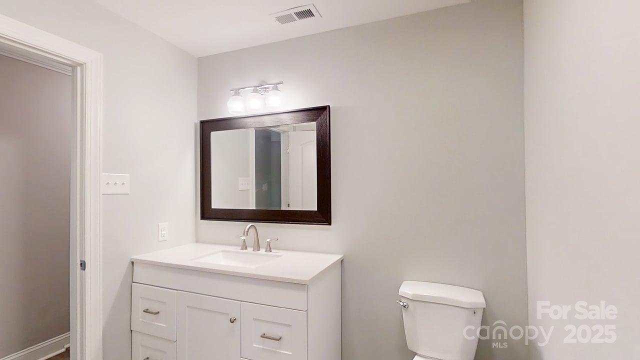 5406 Christopher Road Iron Station, NC 28080 - Photo 16 of 23 a bathroom with a toilet a sink a vanity and mirror