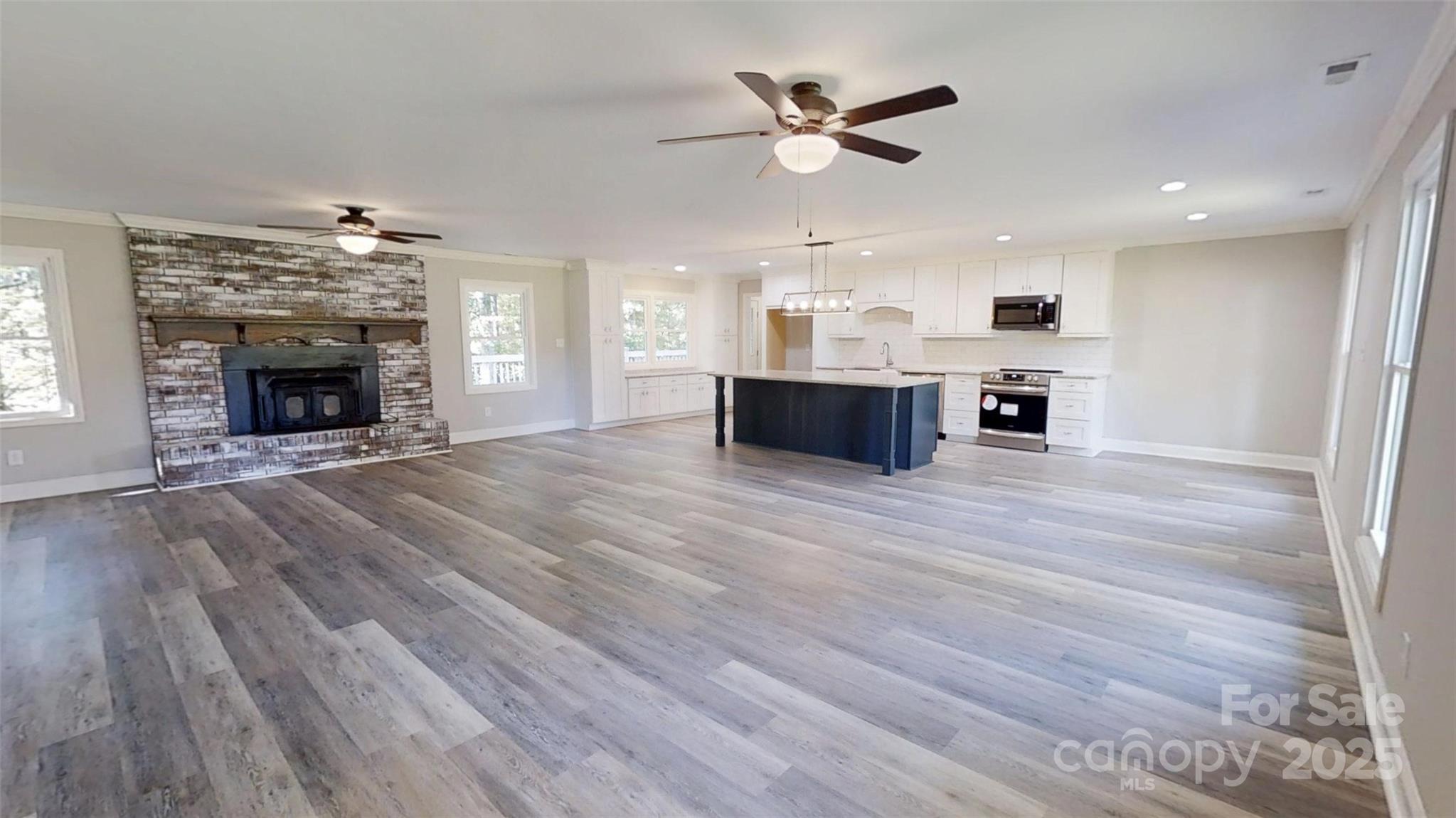 5406 Christopher Road Iron Station, NC 28080 - Photo 2 of 23 an open kitchen with fireplace and wooden floor