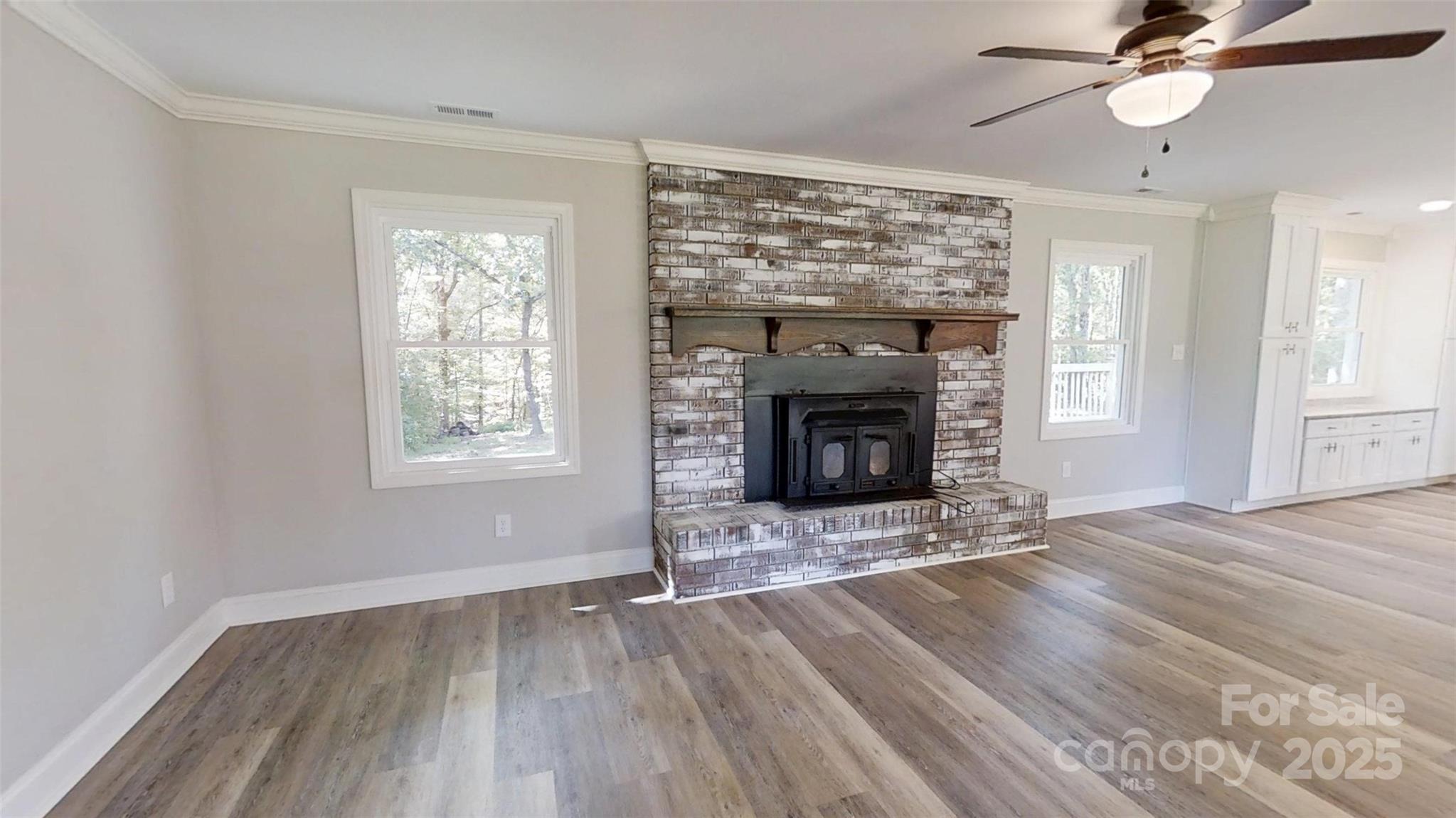 5406 Christopher Road Iron Station, NC 28080 - Photo 4 of 23 wooden floor fireplace and windows in an empty room