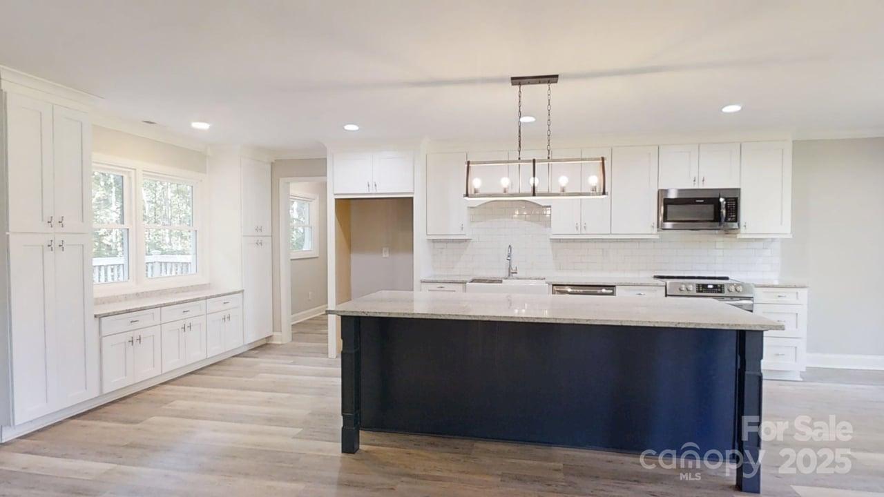 5406 Christopher Road Iron Station, NC 28080 - Photo 5 of 23 a kitchen with kitchen island granite countertop a sink window and cabinets