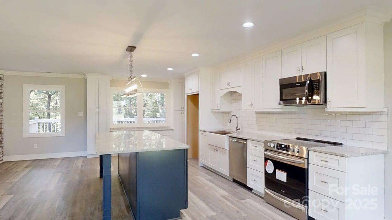 5406 Christopher Road Iron Station, NC 28080 - Photo 6 of 23 a kitchen with stainless steel appliances kitchen island granite countertop a stove a sink and a microwave