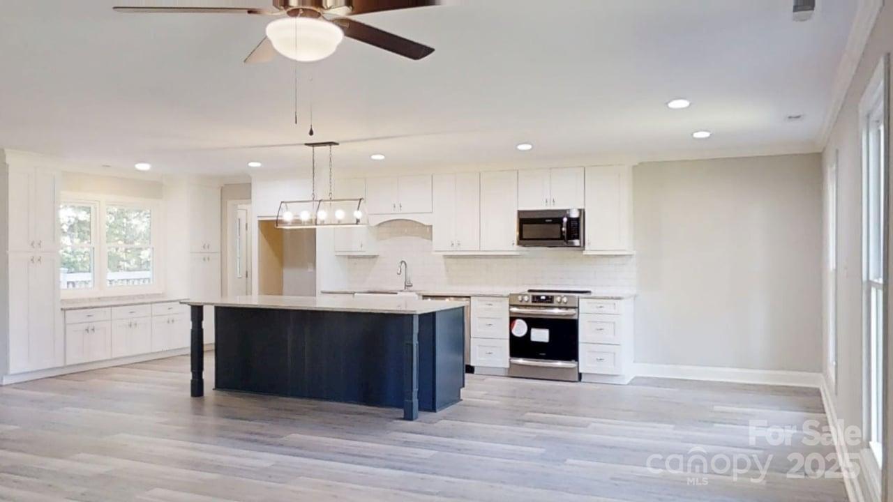 5406 Christopher Road Iron Station, NC 28080 - Photo 7 of 23 a large kitchen with stainless steel appliances granite countertop a stove top oven a sink and a refrigerator