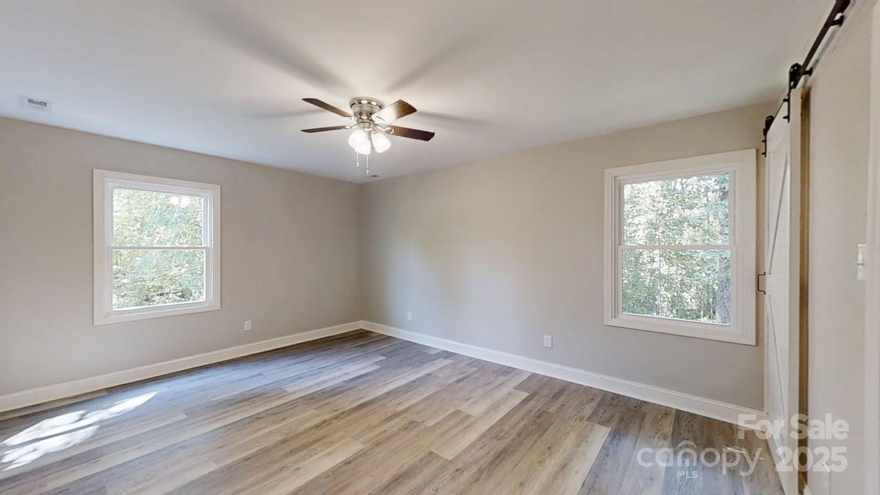 5406 Christopher Road Iron Station, NC 28080 - Photo 9 of 23 a view of empty room with wooden floor and fan