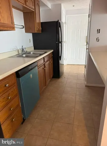 a kitchen with a sink a refrigerator and cabinets
