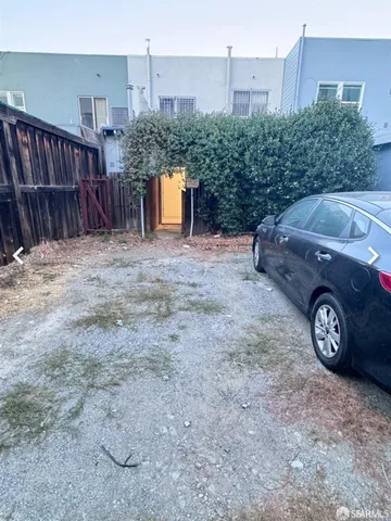 a view of a house with a backyard and parking space