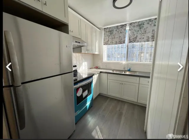 a kitchen with a refrigerator a sink and cabinets