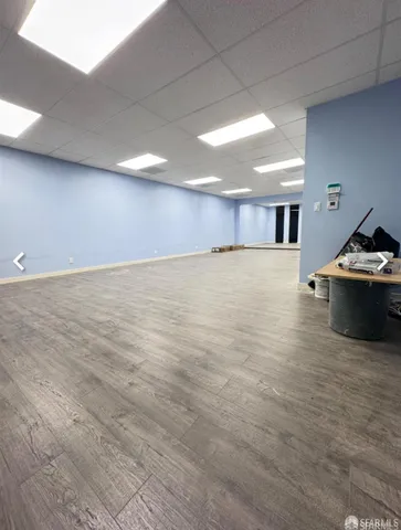 a view of an empty room and a kitchen