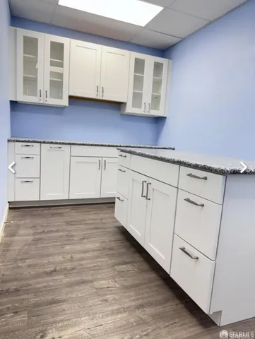 a view of kitchen with granite countertop cabinets and wooden floor
