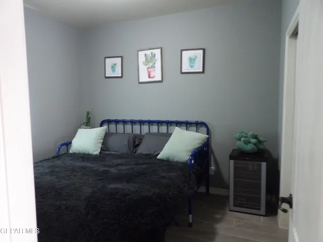 a large bed sitting in a bedroom next to a window with potted plant