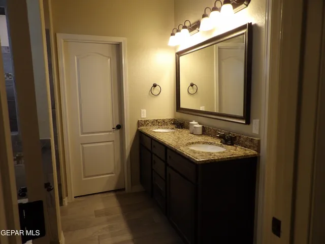 a bathroom with a granite countertop sink and a mirror