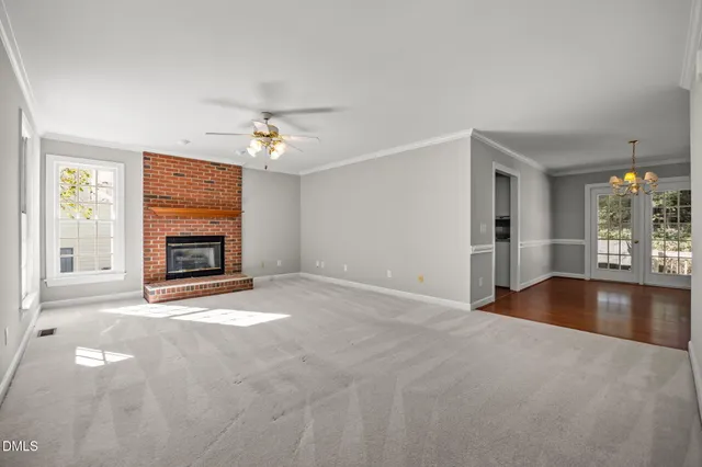 a view of an empty room with a fireplace and a window