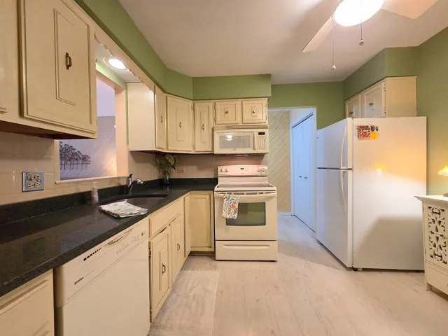 a kitchen with stainless steel appliances granite countertop a refrigerator sink and cabinets