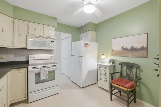 a kitchen with stainless steel appliances white cabinets and a stove top oven