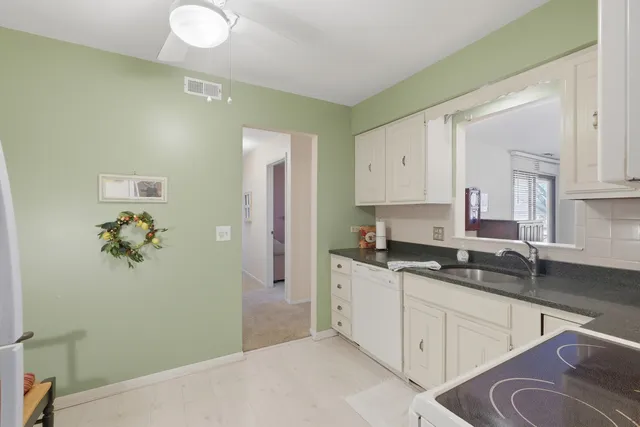 a kitchen with granite countertop a sink cabinets and stainless steel appliances