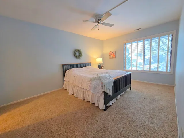 a bed sitting in a spacious bedroom next to a window