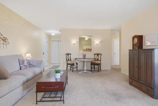 a living room with furniture and a dining table with kitchen island