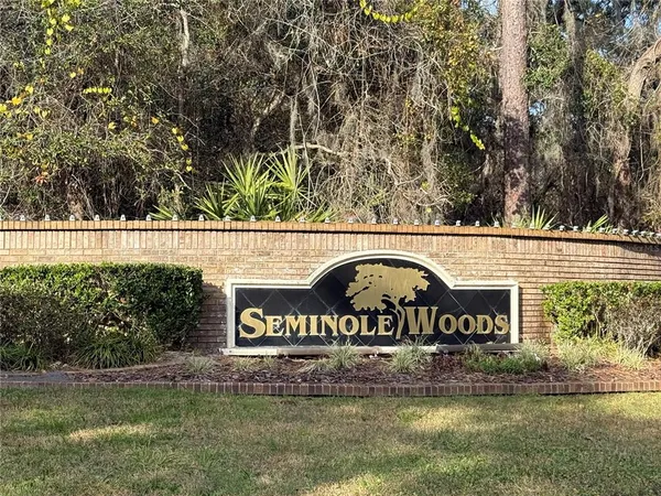 a view of a street sign under a large tree