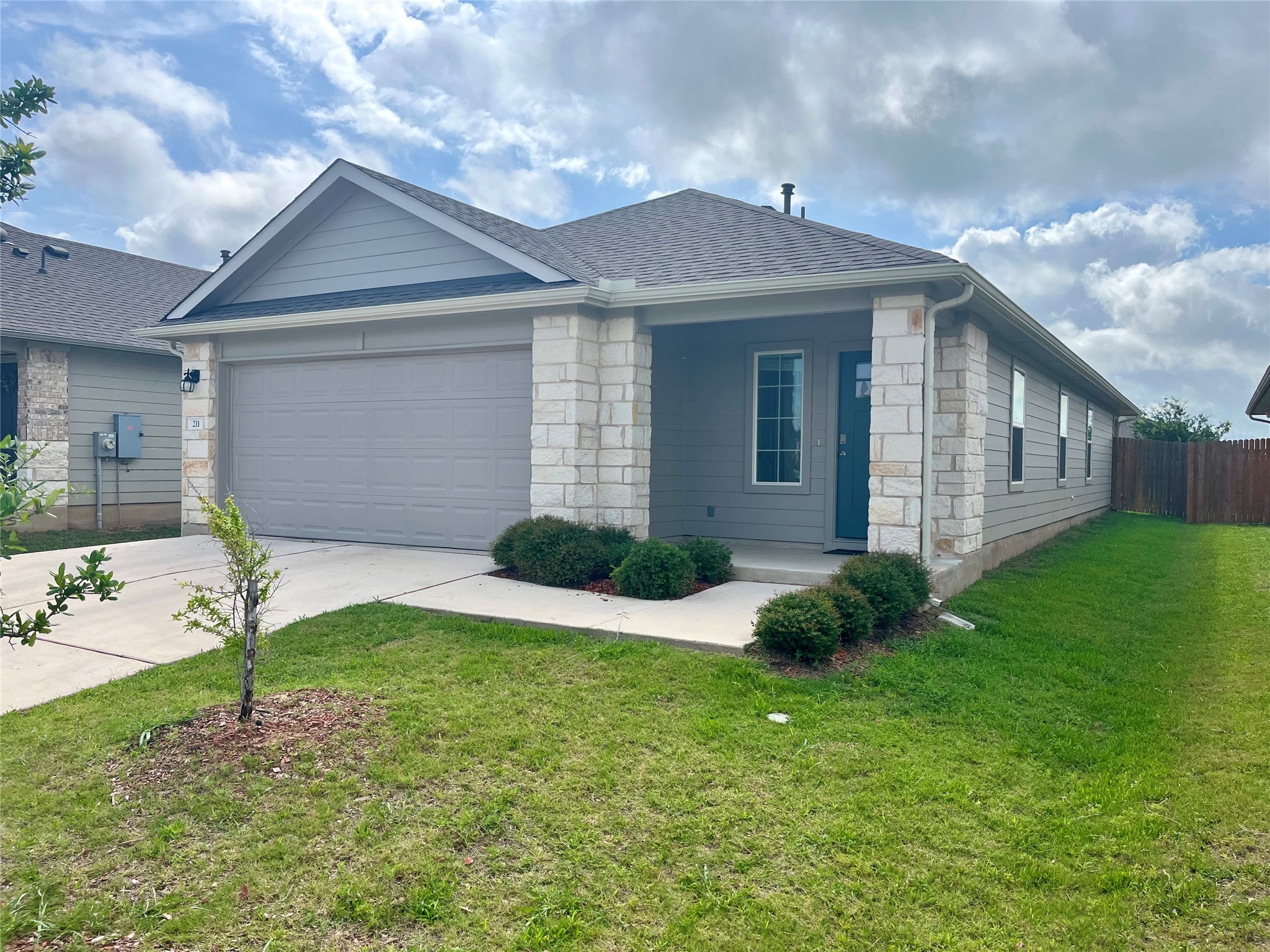 211 Hamilton Pool Lane Bastrop, TX 78602 - Photo 1 of 11 a front view of a house with a yard and garage