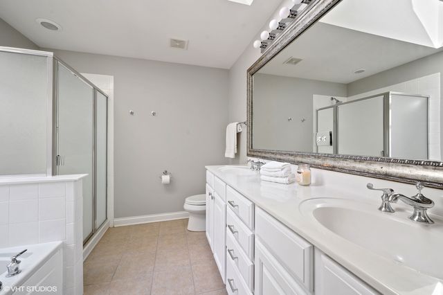 a spacious bathroom with a double vanity sink mirror and toilet