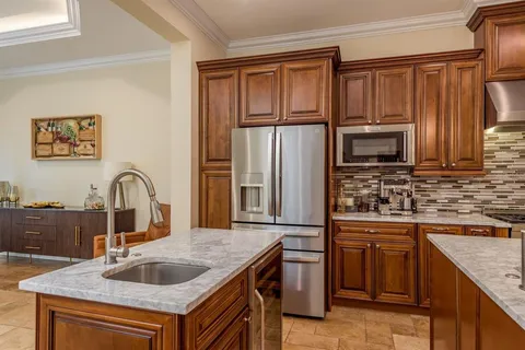 a kitchen with granite countertop a sink stove and refrigerator