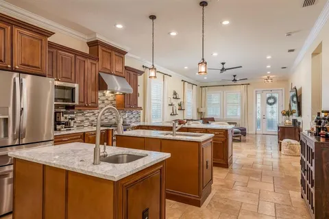 a kitchen with stainless steel appliances granite countertop a sink a stove and a refrigerator