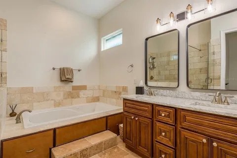 a bathroom with double vanity sinks double vanity tub and a mirror