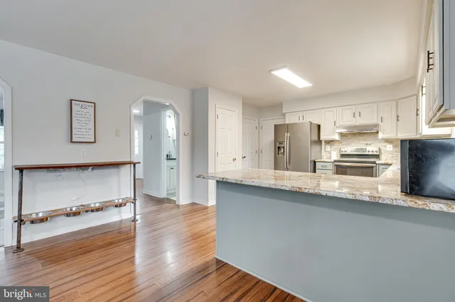 a kitchen with white cabinets and sink