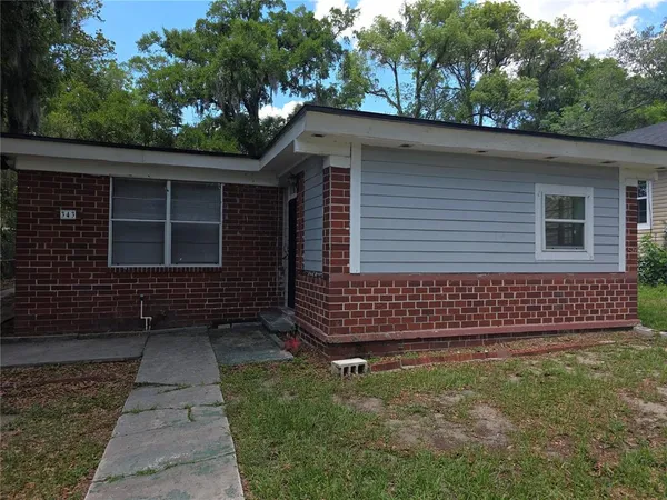 a front view of a house with a garden