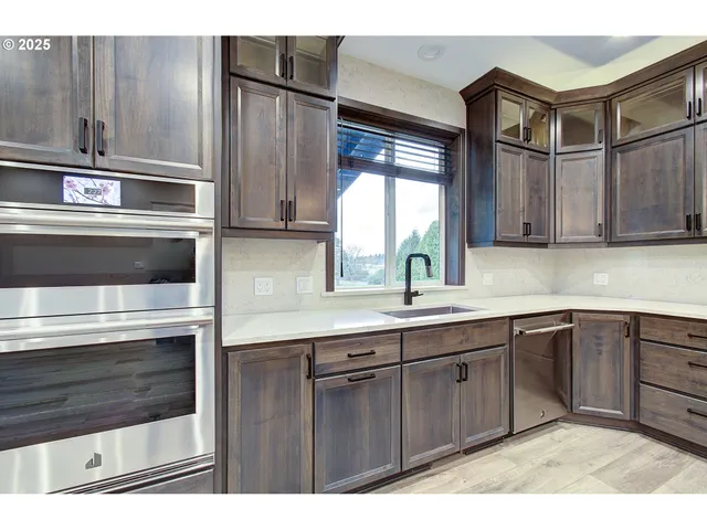 a kitchen with stainless steel appliances kitchen island wooden cabinets and a sink