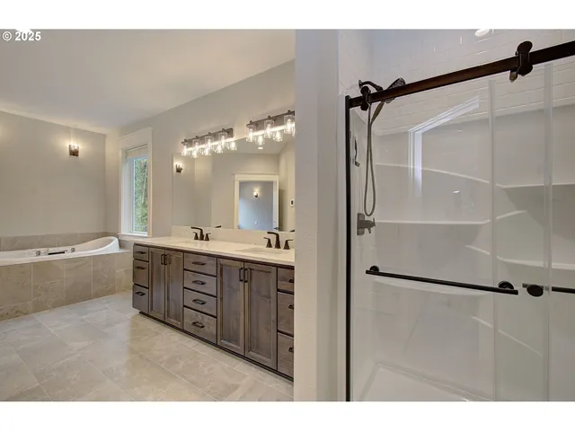 a bathroom with a double vanity sink mirror and shower