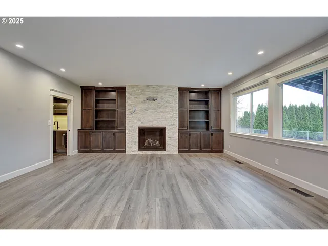 a view of an empty room with a window and fireplace