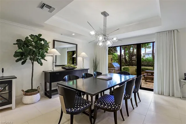 a dining room with furniture potted plants and wooden floor