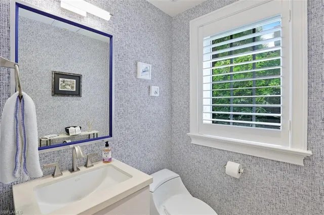 a bathroom with a sink a toilet and a mirror