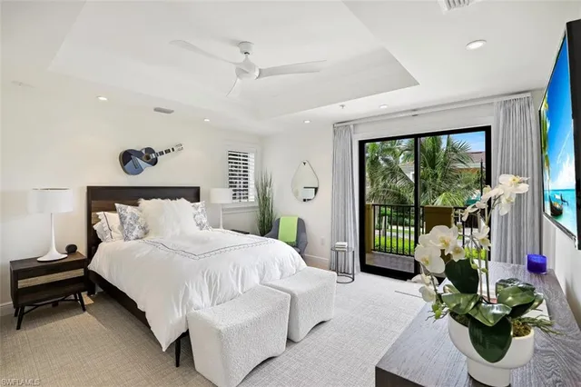 a bedroom with a bed and large windows