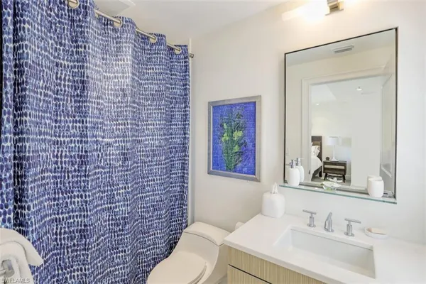 a bathroom with a sink a toilet and mirror