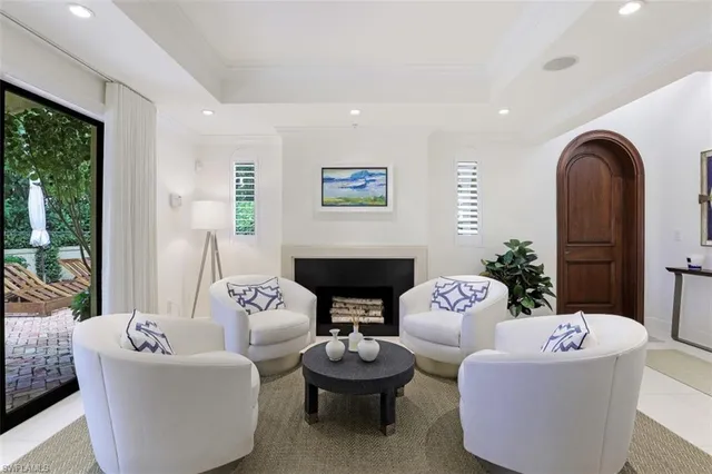 a living room with fireplace furniture and a large window