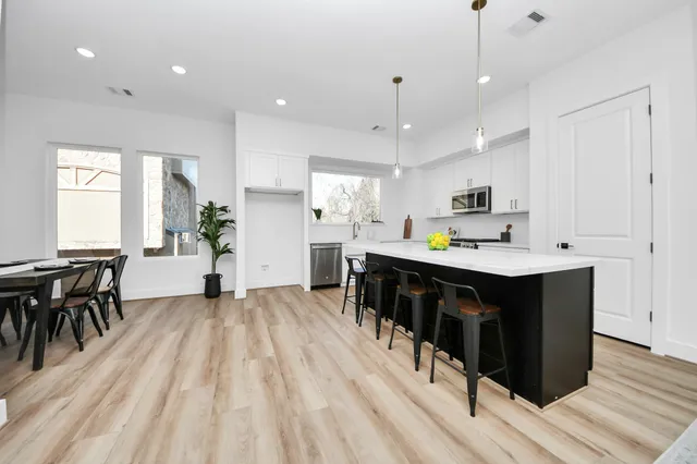 an open kitchen with kitchen island and stainless steel appliances