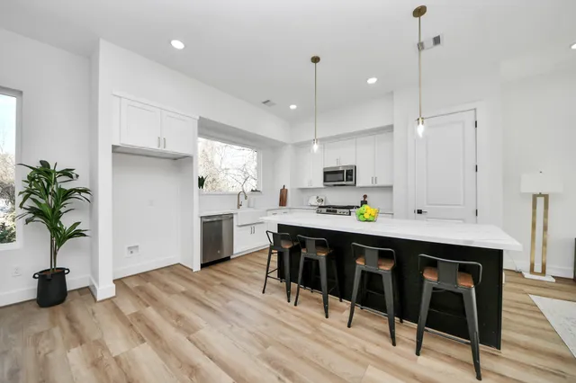 a kitchen with a table chairs refrigerator and sink
