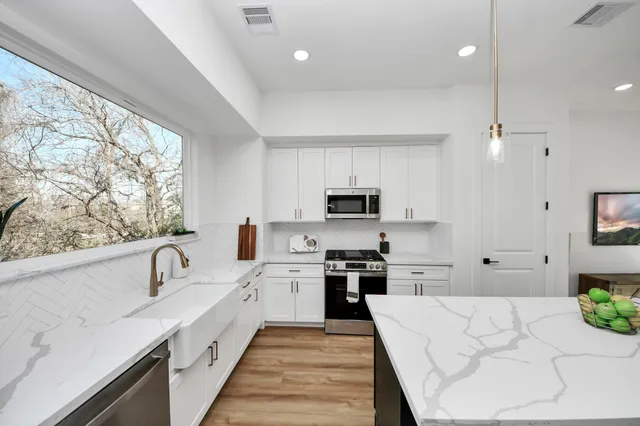 a large kitchen with stainless steel appliances lots of counter space sink and cabinets