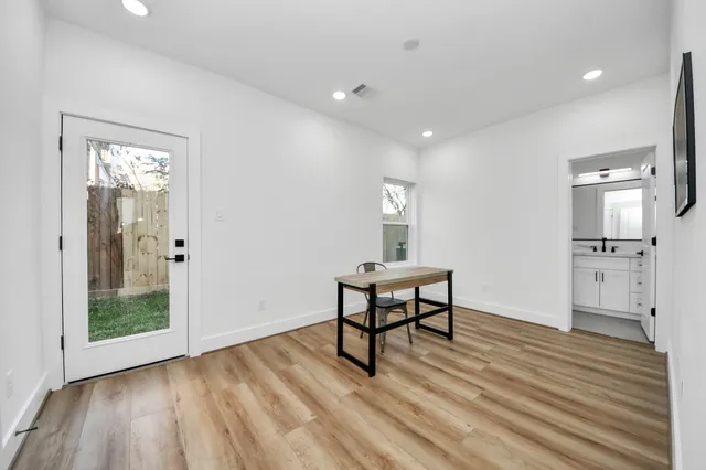 a view of a room with wooden floor bathroom and windows