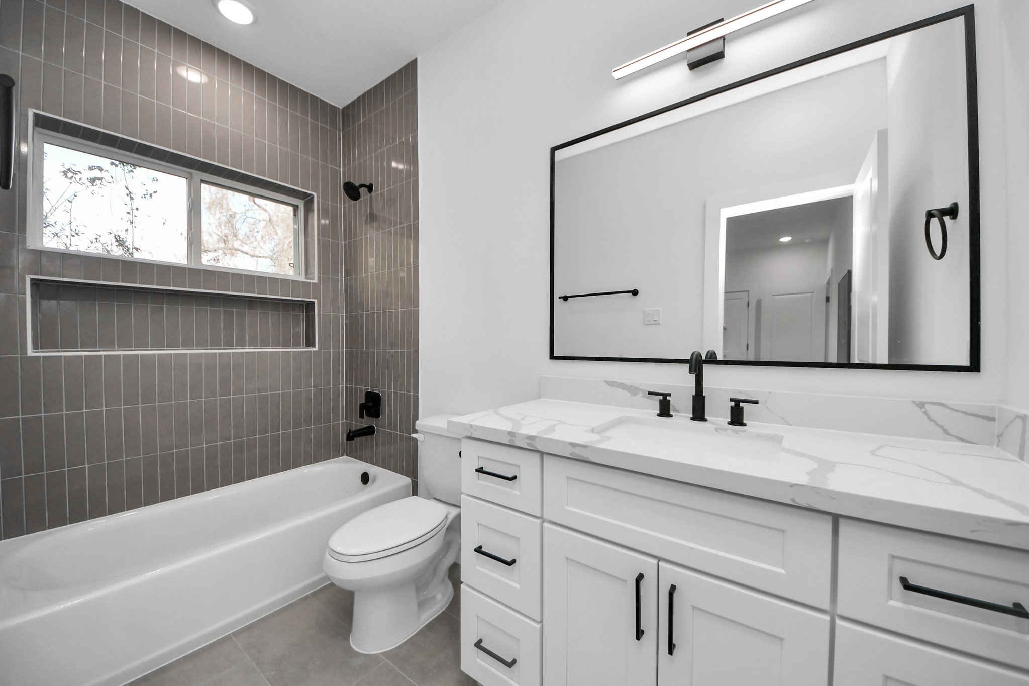 4804 Elysian Street, Unit B Houston, TX 77009 - Photo 6 of 49 a bathroom with a toilet a bath tub a sink and a large mirror