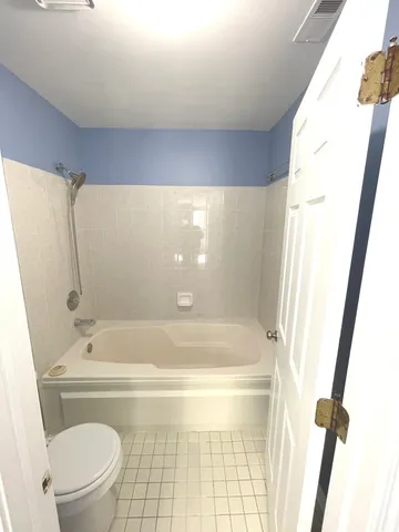 a bathroom with a tub and a toilet