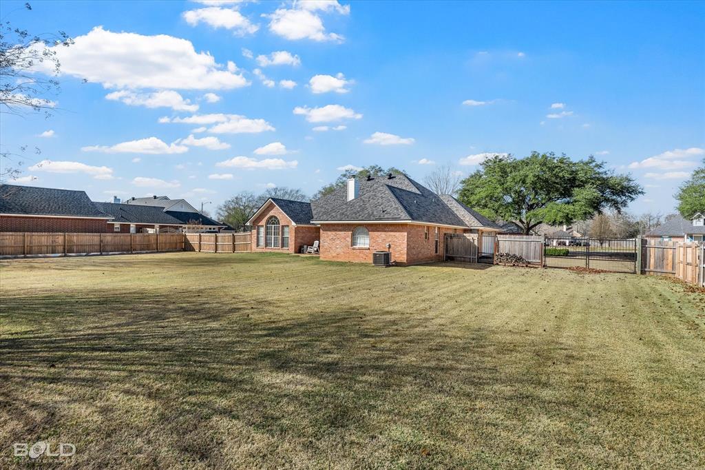 218 Ridgefield Drive Bossier City, LA 71111 - Photo 32 of 40 Back of property with a fenced backyard and brick siding