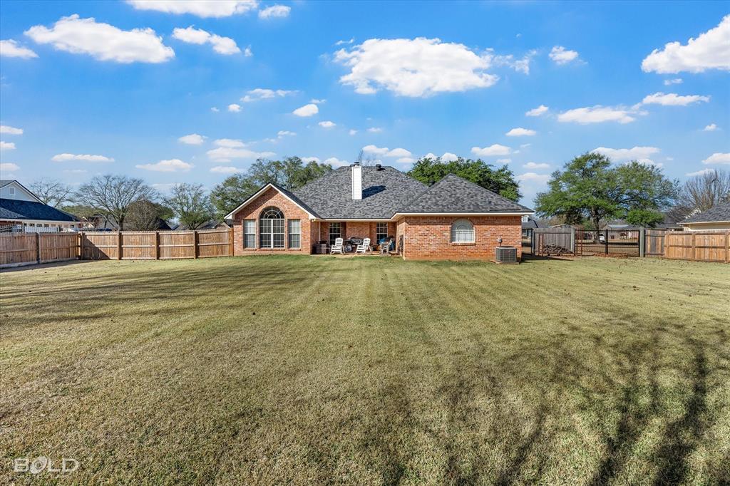 218 Ridgefield Drive Bossier City, LA 71111 - Photo 33 of 40 Rear view of house featuring a fenced backyard, brick siding, a patio area, and a chimney