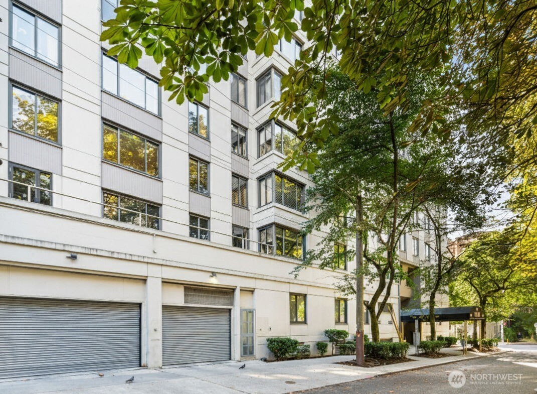 1105 Spring Street, Unit 211 Seattle, WA 98104 - Photo 25 of 26 a view of a building and a tree