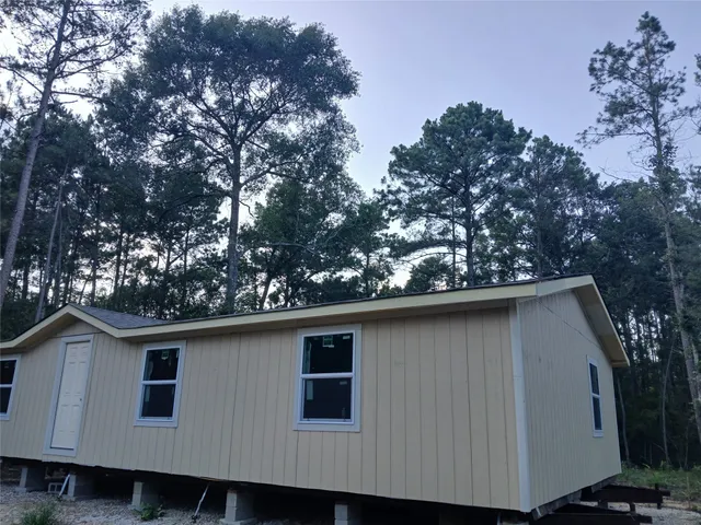 a side view of a house with a tree