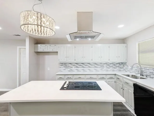 a kitchen with a stove a sink and a dining table