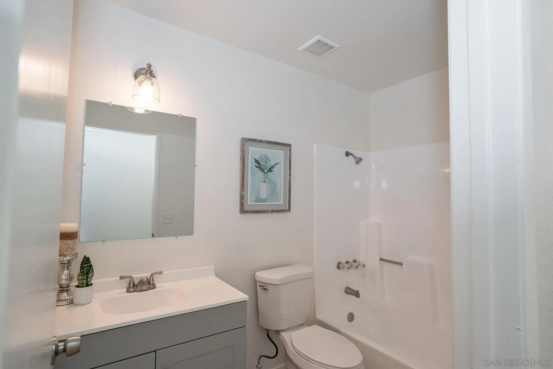 5145 Francis Street Oceanside, CA 92057 - Photo 19 of 21 a bathroom with a toilet sink vanity and mirror